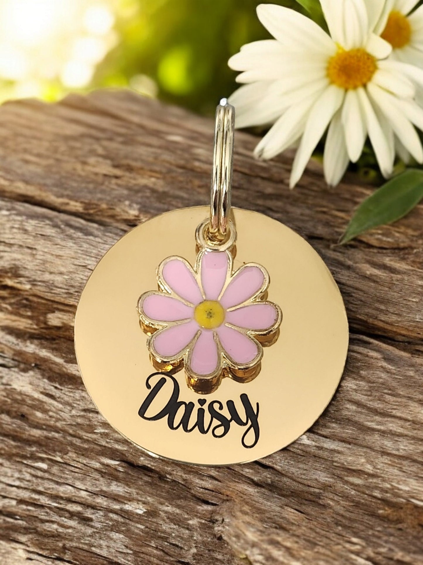 Gold pet ID tag with pink or blue daisy charm.